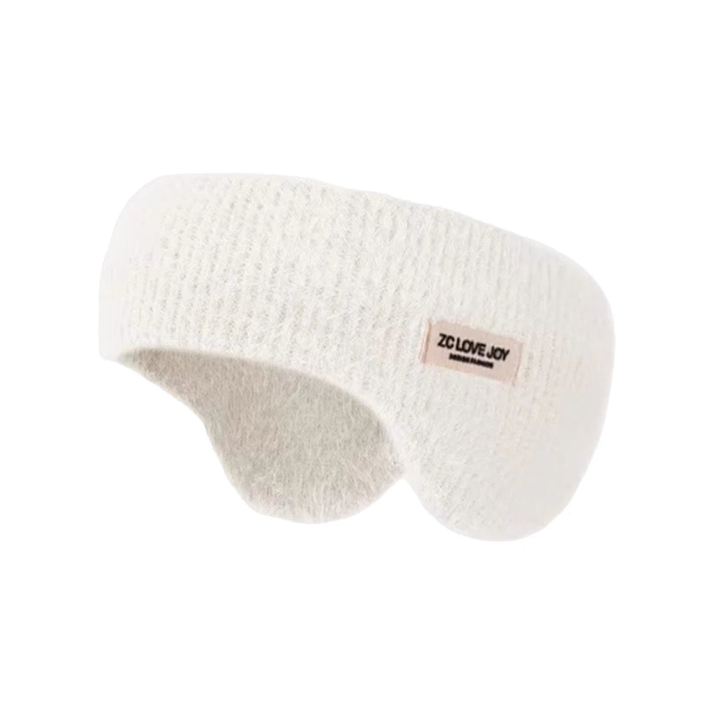 White knit winter ear warmer headband with a small beige tag, shown on a plain white background