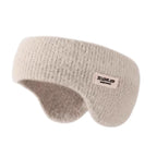 Beige knitted winter ear warmer headband with a small label, shown on a plain white background