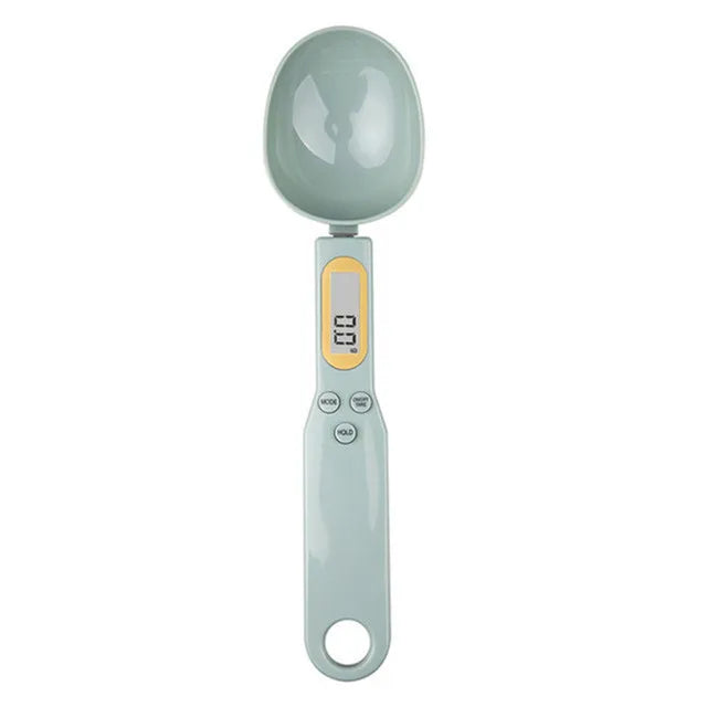 Light gray digital measuring spoon scale with LCD display and buttons shown from overhead view