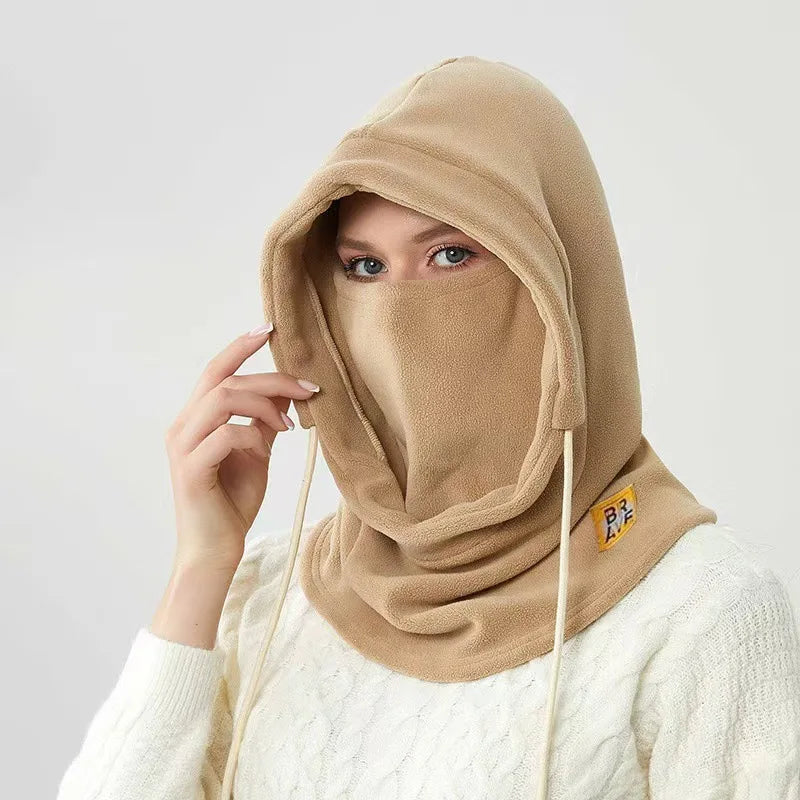 Person wearing a tan fleece winter hood with drawstrings and a face covering, shown from the front