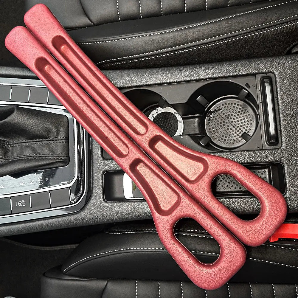Pair of red car seat gap fillers resting across a black car center console with cup holders