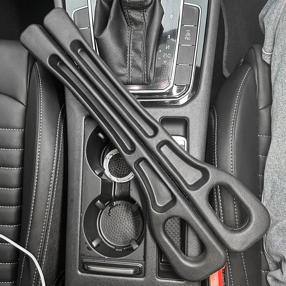 Pair of black foam car seat gap fillers placed on a car's center console between seats