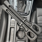 Pair of black foam car seat gap fillers resting on a center console between seats and gear shift
