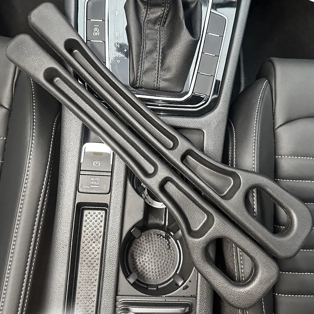 Pair of black foam car seat gap fillers resting on a center console between seats and gear shift