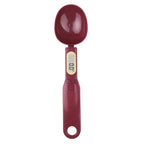 Burgundy digital measuring spoon with LCD display, shown from above on a white background