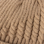 Close-up of a tan cable knit beanie showing detailed ribbed and twisted knit pattern