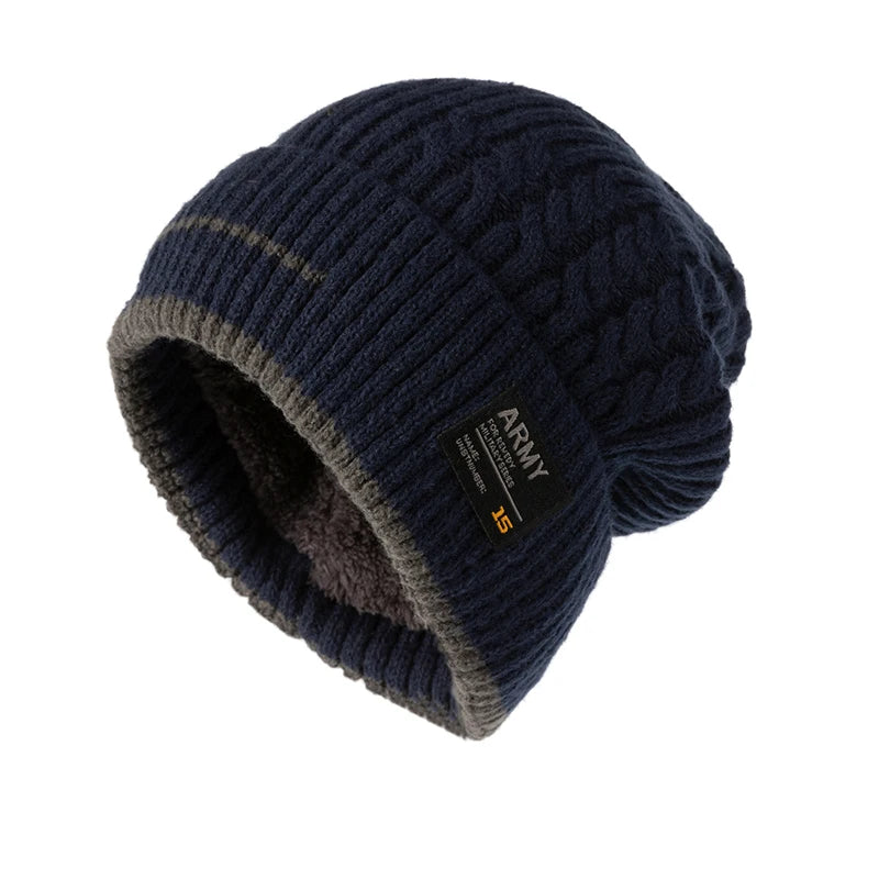 Navy blue cable knit beanie with gray trim and a fabric patch, shown angled on a white background