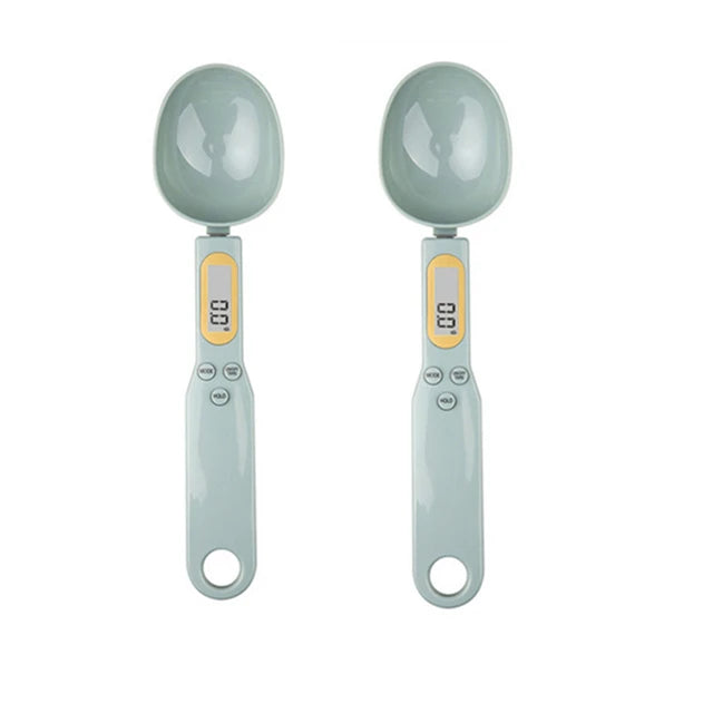 Two grey digital measuring spoon scales with display screens, shown side by side on a white background