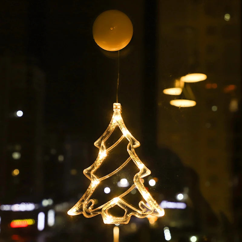 Warm white LED Christmas tree ornament hanging on a window with city lights in the background