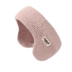 Light pink fluffy knit ear warmer headband with a small white label, shown on a white background