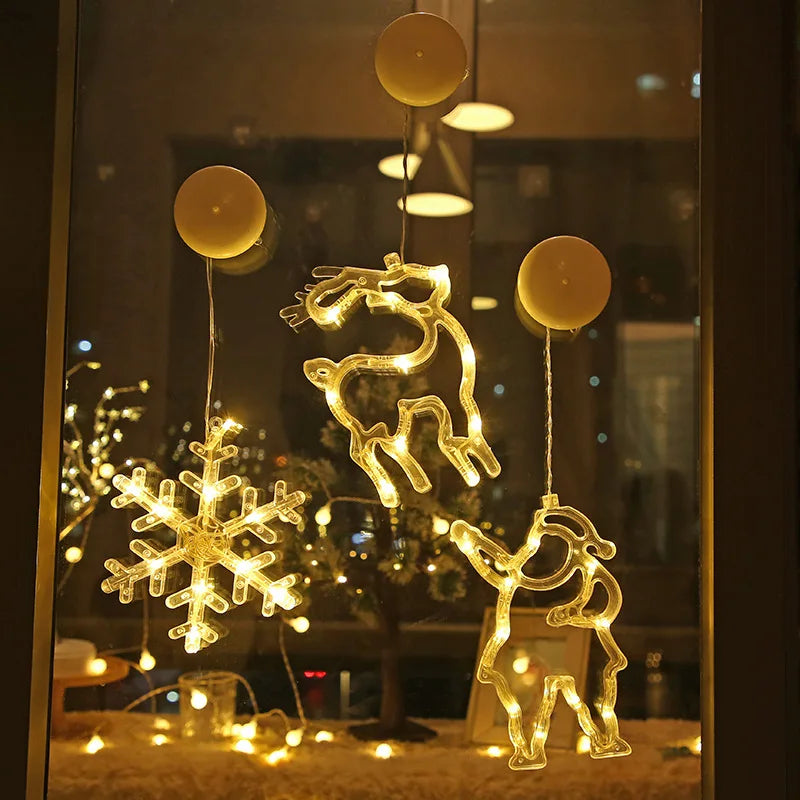 Warm white LED Christmas ornaments shaped like a snowflake, reindeer, and Santa hanging on a window