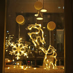 Warm white LED Christmas ornaments shaped like a snowflake, reindeer, and Santa hanging on a window