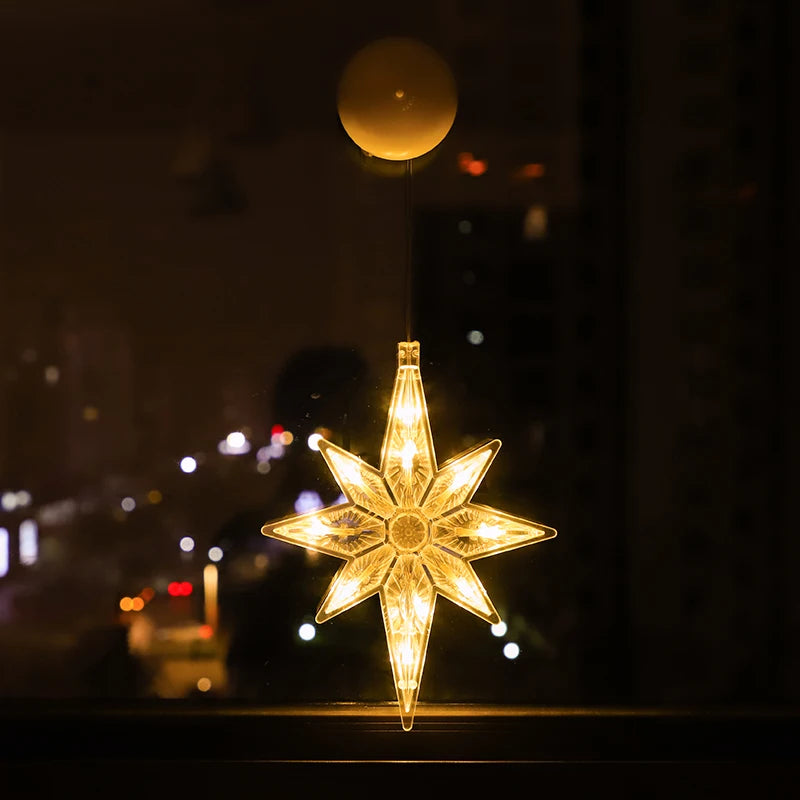 Warm white LED star-shaped ornament hanging on a window with city lights blurred in the background
