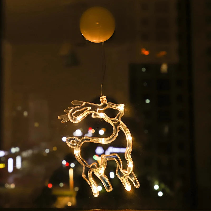 Warm white LED reindeer ornament hanging from a window at night with city lights in the background