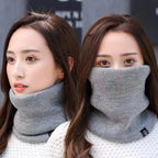 Two women wearing light grey knitted neck warmers, one with it covering the neck and one over the face
