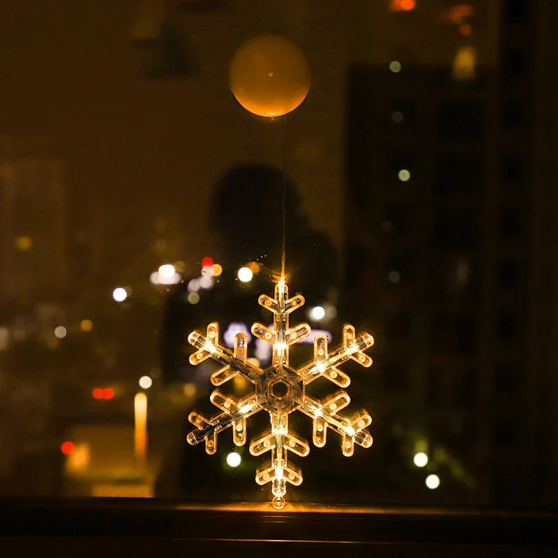 Transparent LED snowflake ornament glowing warm white, hanging on a window at night