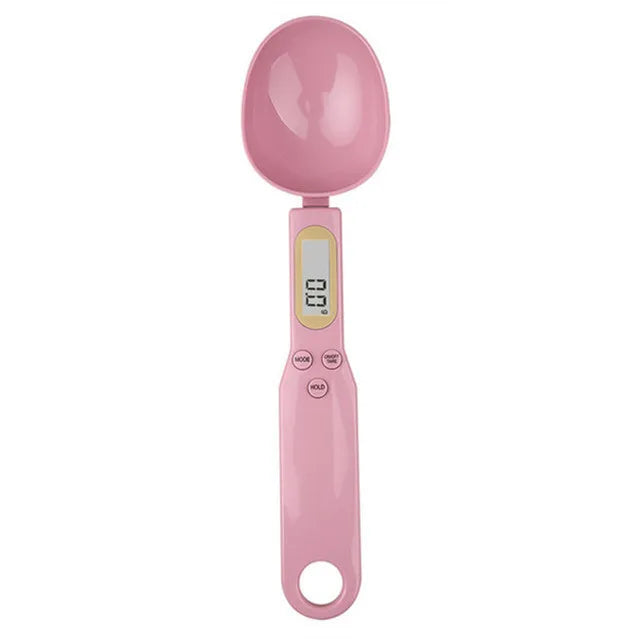 Pink digital measuring spoon scale with LCD display and buttons, shown from above on white background