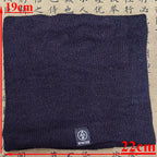 Black knitted neck warmer with a small winter label, laid flat showing 19cm by 22cm dimensions
