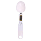 White digital measuring spoon scale with LCD display and control buttons, shown on white background
