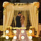 Warm white solar curtain string lights hanging on a floral wedding arch, illuminated outdoors at night