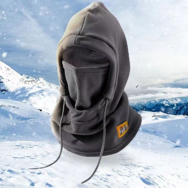 Gray fleece winter hood with drawstrings and face cover, shown on a snowy mountain background