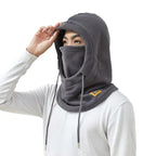 Person wearing a grey fleece winter hood with face cover and drawstrings, shown from the side