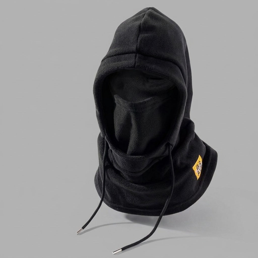 Black fleece winter hood with drawstrings and a yellow patch, displayed on a plain gray background