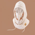 Beige fleece winter hood with drawstrings and face cover, shown against a plain brown background