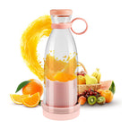 Clear and pink portable blender bottle with orange slices inside, fruit basket and juice splash behind