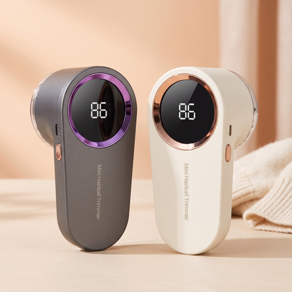 Two rechargeable lint removers, one grey with purple trim and one white with rose gold trim, standing on a beige surface
