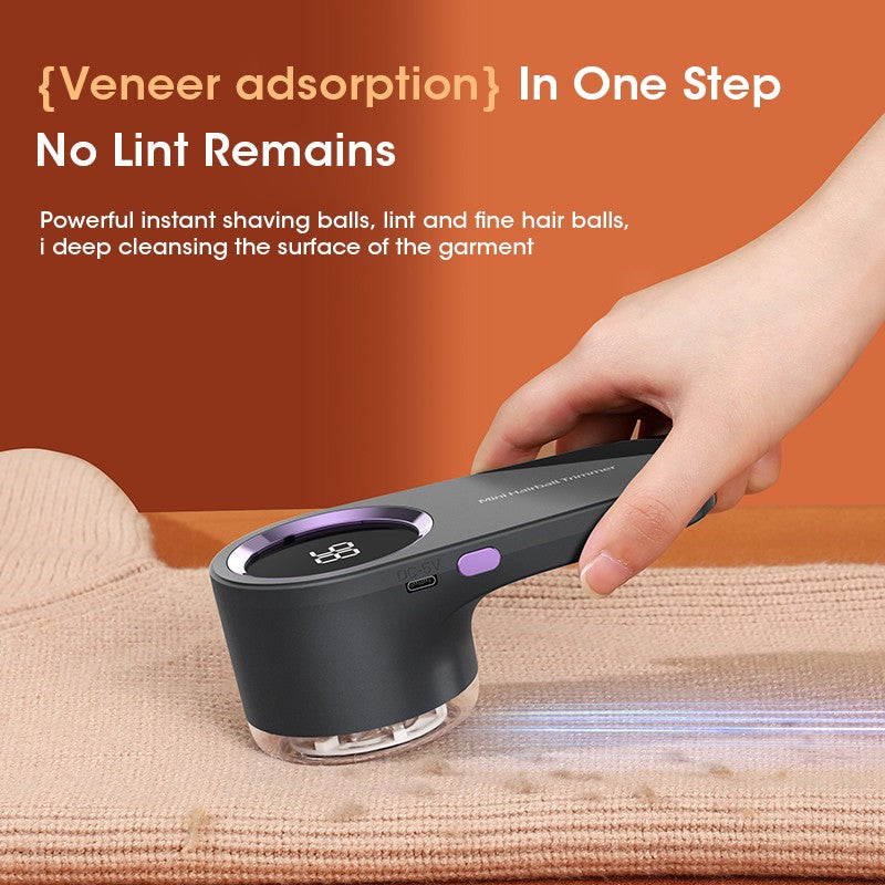 Hand using a black rechargeable lint remover with LED display on a beige knit sweater, close-up view